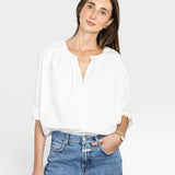 JONES + CO white cotton Julienne long sleeve top with keyhole neckline and pleating. Model wears jeans.