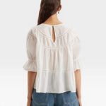 JONES + CO white 100% Pima cotton lawn Sol top with crochet lace trim, puff sleeves, and tiered silhouette.