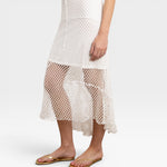 JONES + CO white crochet midi skirt with asymmetrical hem and open knit detail.
