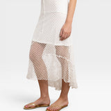 JONES + CO white crochet midi skirt with asymmetrical hem and open knit detail.