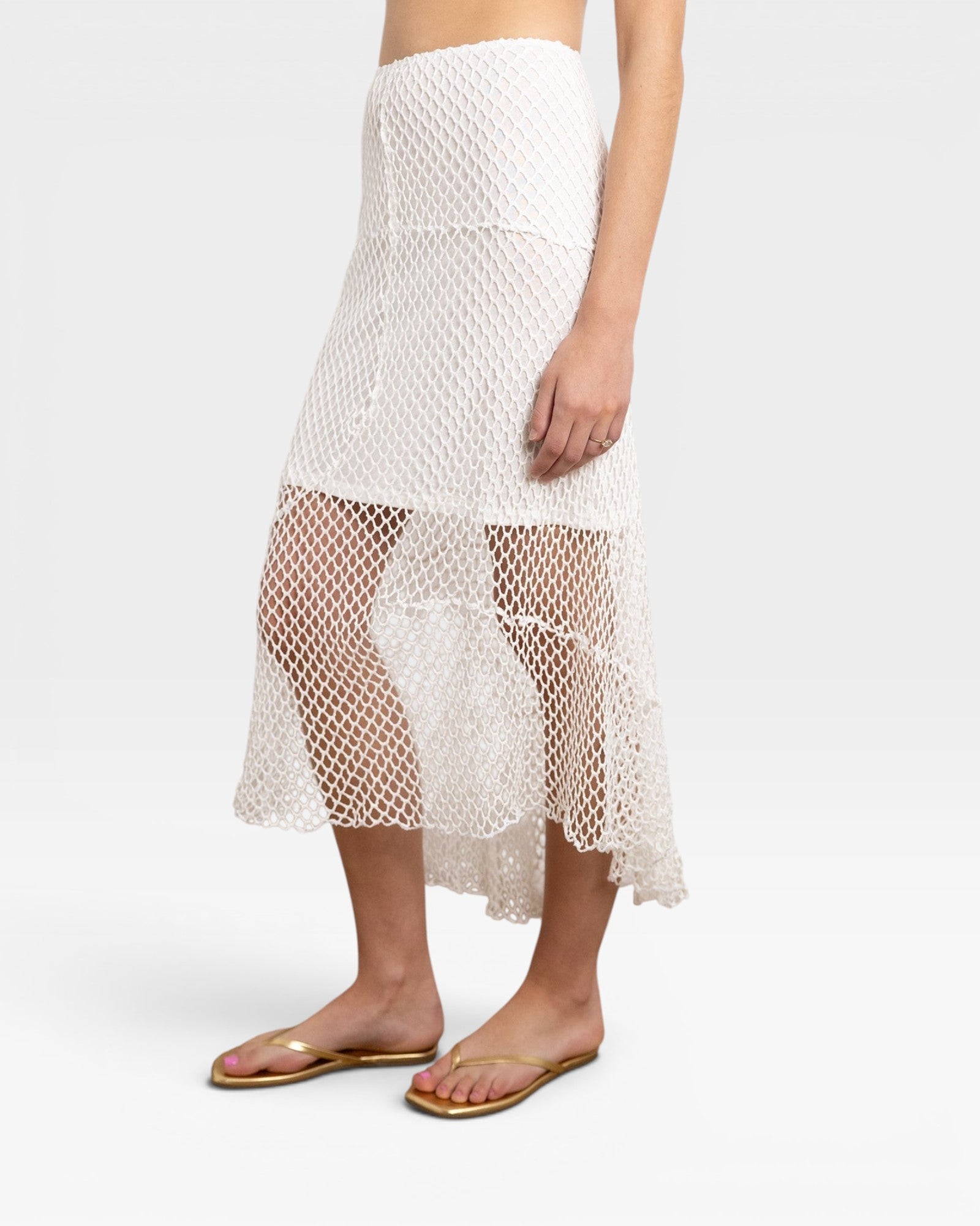 JONES + CO white crochet midi skirt with asymmetrical hem and open knit detail.