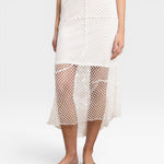 JONES + CO white crochet midi skirt with asymmetrical hem and fishnet-like texture.