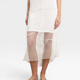 JONES + CO white crochet midi skirt with asymmetrical hem and fishnet-like texture.