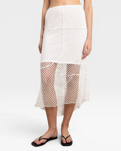 JONES + CO white crochet midi skirt with asymmetrical hem and fishnet-like texture.