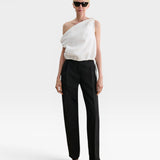 Model wearing JONES + CO white one-shoulder Farfalla top in Italian Foam fabric with draped silhouette and drawstring.