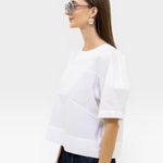 JONES + CO white organic cotton boxy fit rugby top with paneled detail and short sleeves.