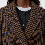 JONES + CO double-breasted wool-blend blazer in sand beige with a blue and black oversized check pattern and wide lapels.