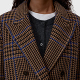 JONES + CO double-breasted wool-blend blazer in sand beige with a blue and black oversized check pattern and wide lapels.