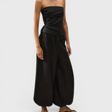 JONES + CO Alzira strapless black linen top with asymmetric front pleats and back tie detail on a model
