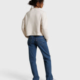 Model wearing JONES + CO Arden mock neck sweatshirt in sugar French terry with blue denim jeans, back view