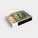 JONES + CO artistic matchbox featuring a green abstract figure illustration, partially open with wooden matches.