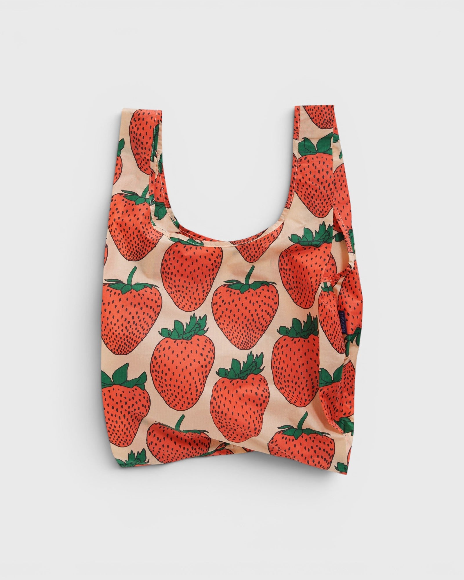 JONES + CO Baggu reusable tote bag in beige with a red and green strawberry print made from lightweight nylon
