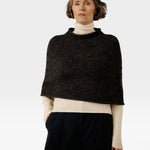 JONES + CO seamless alpaca-blend poncho in basalt grey worn over a cream turtleneck sweater
