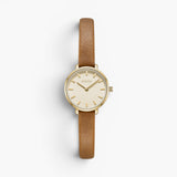 JONES + CO Beverly watch featuring a gold case, cream dial, and slim brown leather strap on a white background.
