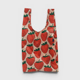 JONES + CO Big Baggu reusable tote bag in a light pink fabric with a red and green strawberry print pattern.