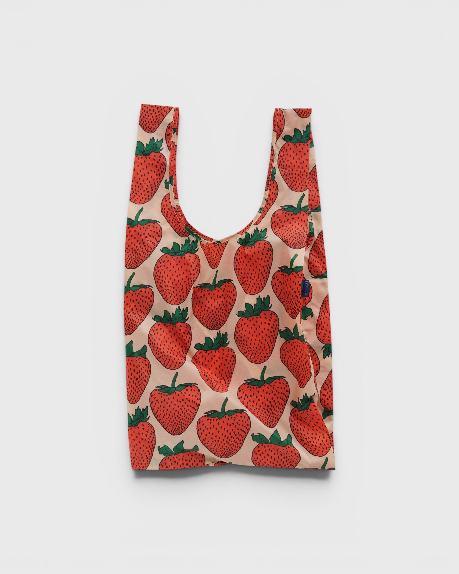 JONES + CO Big Baggu reusable tote bag in a light pink fabric with a red and green strawberry print pattern.