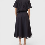 JONES + CO black midi skirt with cut-out embroidery hem, worn with matching short-sleeve shirt, back view