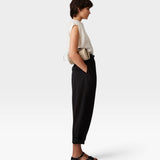 JONES + CO Brady black wool trousers with a high-waisted, tapered, cropped fit worn by a model in profile view.