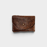 JONES + CO brown cowhide hair-on-hide cardholder with a solid brass fastener, front view.
