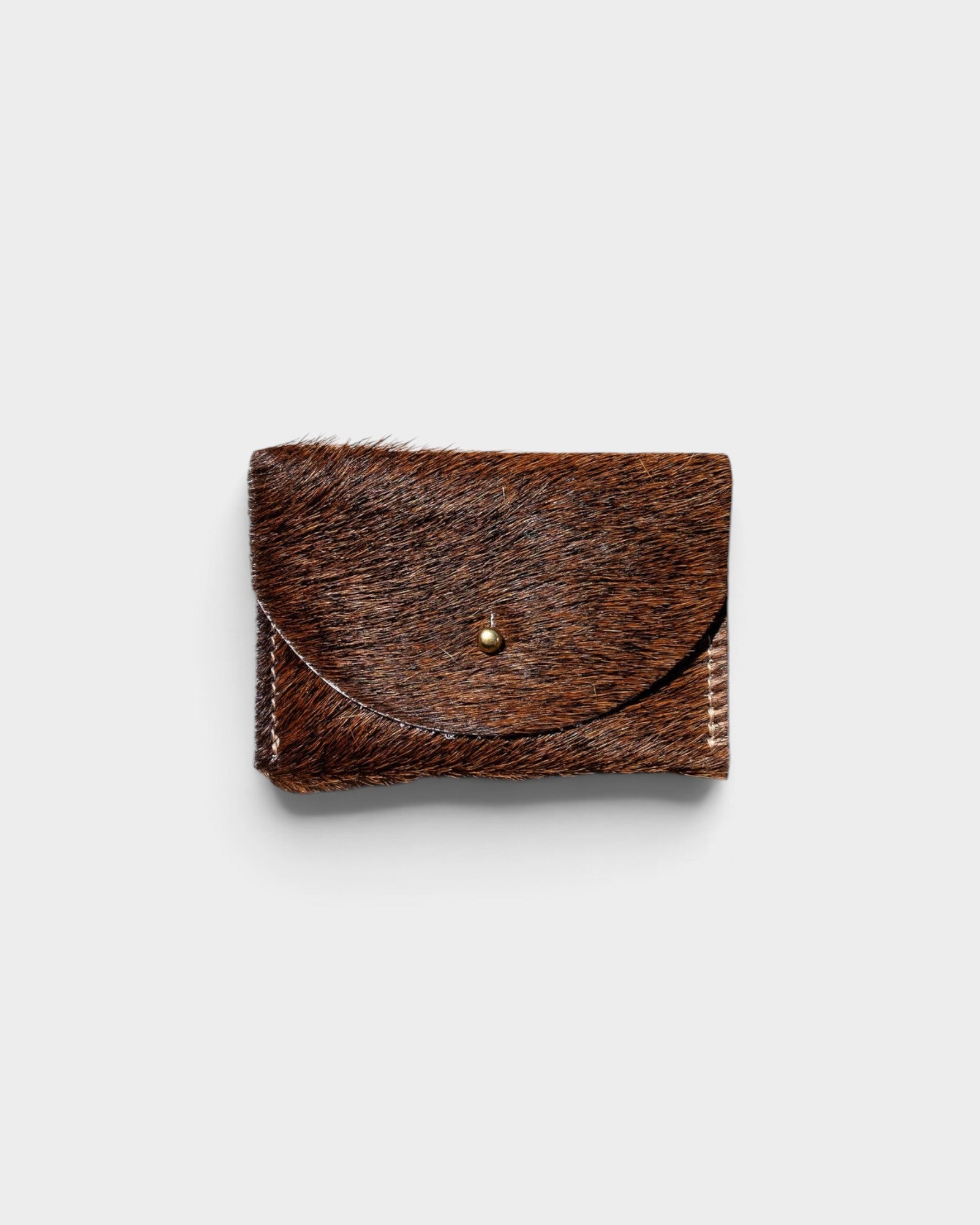 JONES + CO brown cowhide hair-on-hide cardholder with a solid brass fastener, front view.