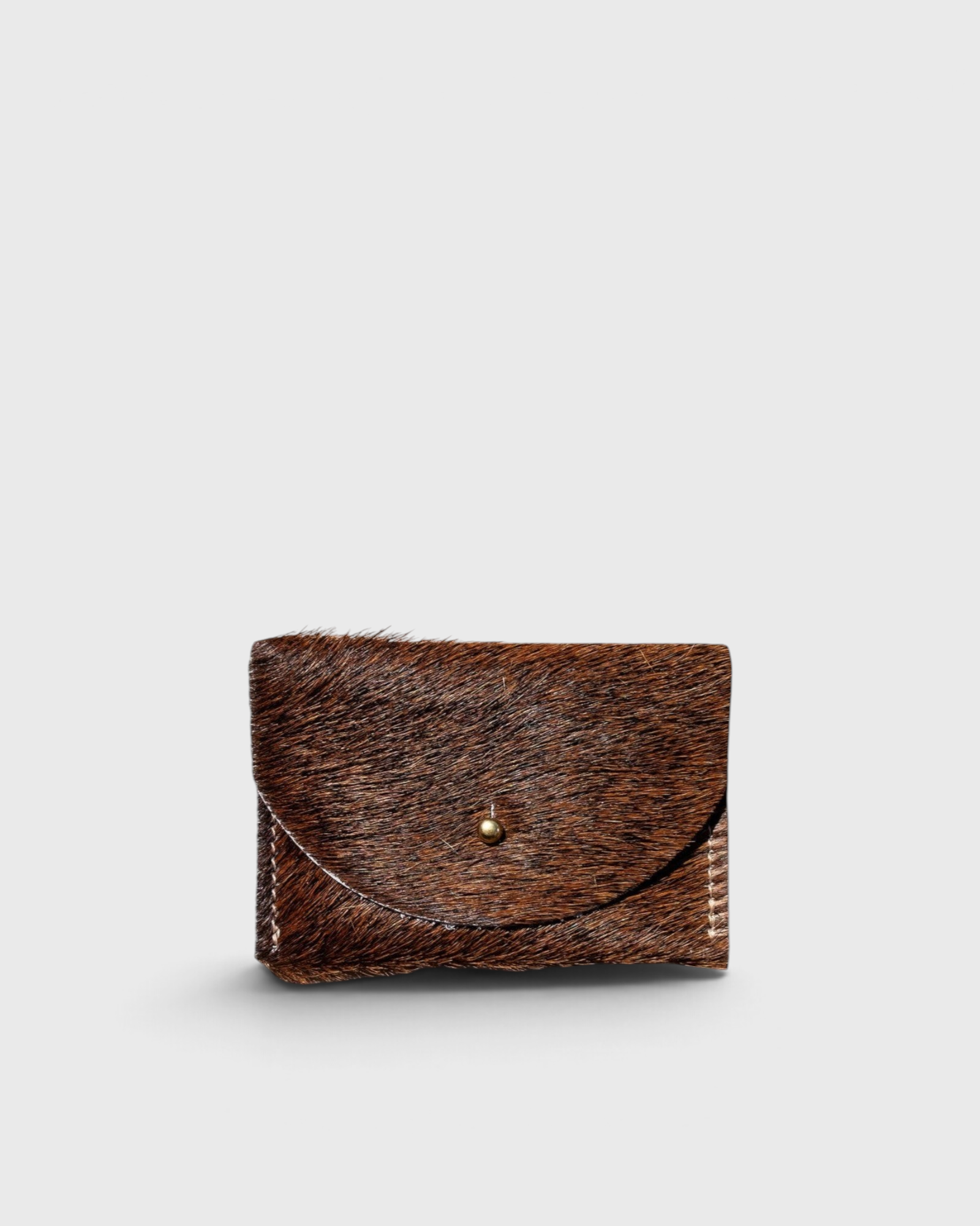 JONES + CO brown cowhide hair-on-hide cardholder with a solid brass fastener, front view.