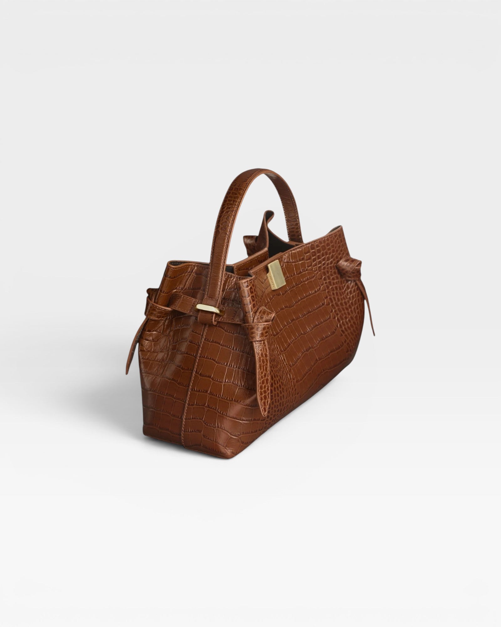 JONES + CO Gyoza pouch in brown embossed leather with a structured handle and gold hardware details.