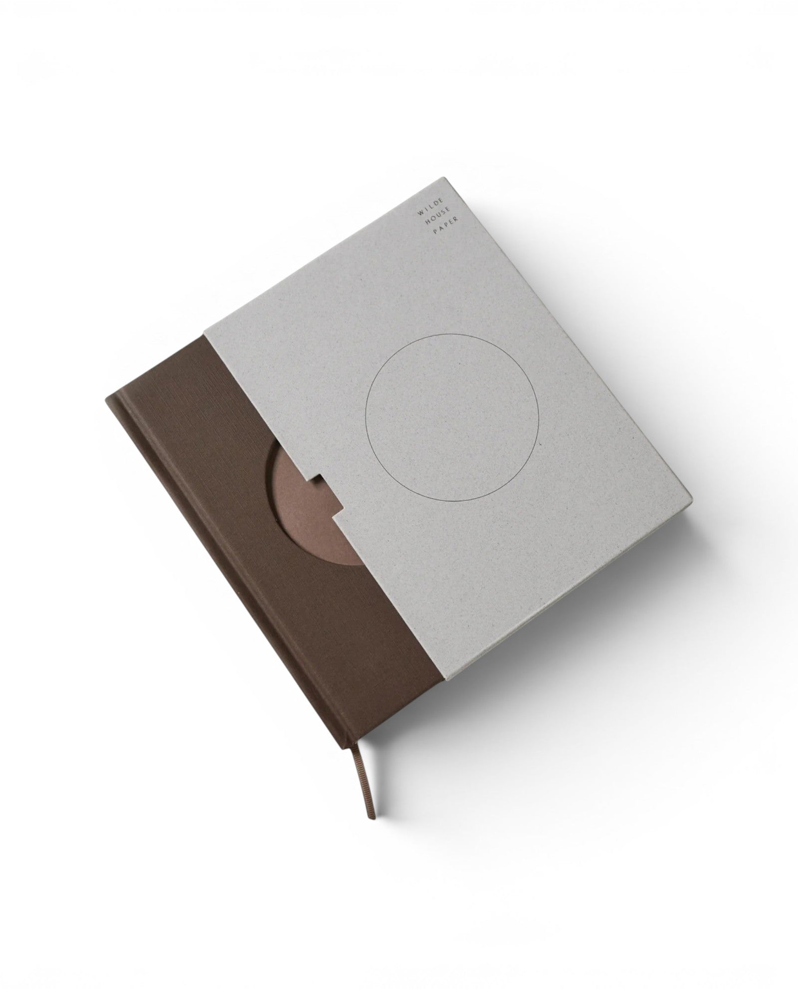 JONES + CO Open Journal with a brown fabric cover and light grey textured slipcase featuring a circular cutout.