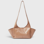 JONES + CO camel leather Tool Bag with a sculptural silhouette, fixed shoulder strap, and extended side pockets.