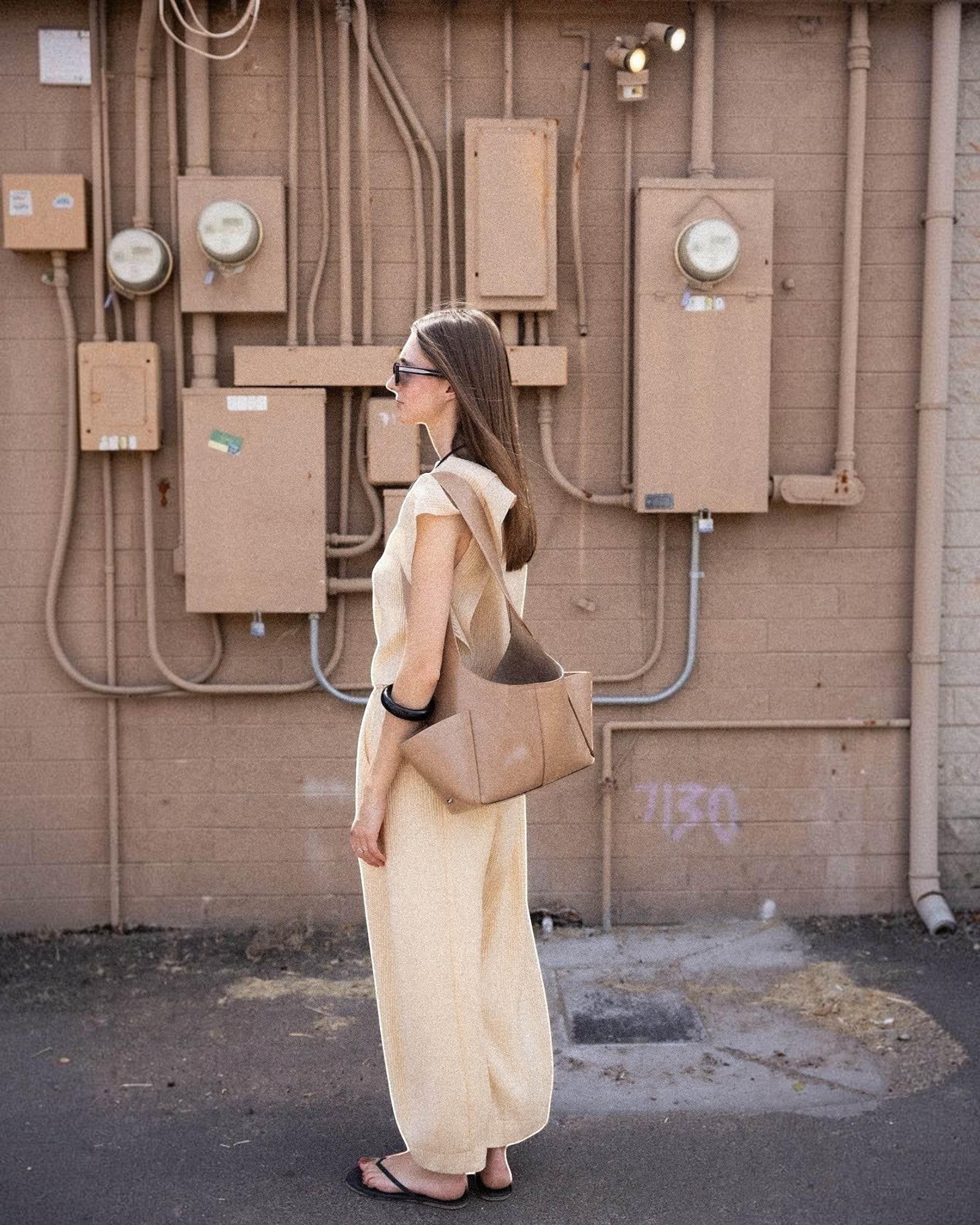 JONES + CO camel Tool Bag with shoulder strap and exterior pockets worn by a woman in a matching beige outfit.
