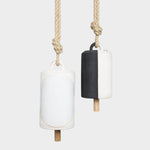 JONES + CO Thrown Bell Domino Indigo set featuring two ceramic bells with rope hangers in white and black finishes.