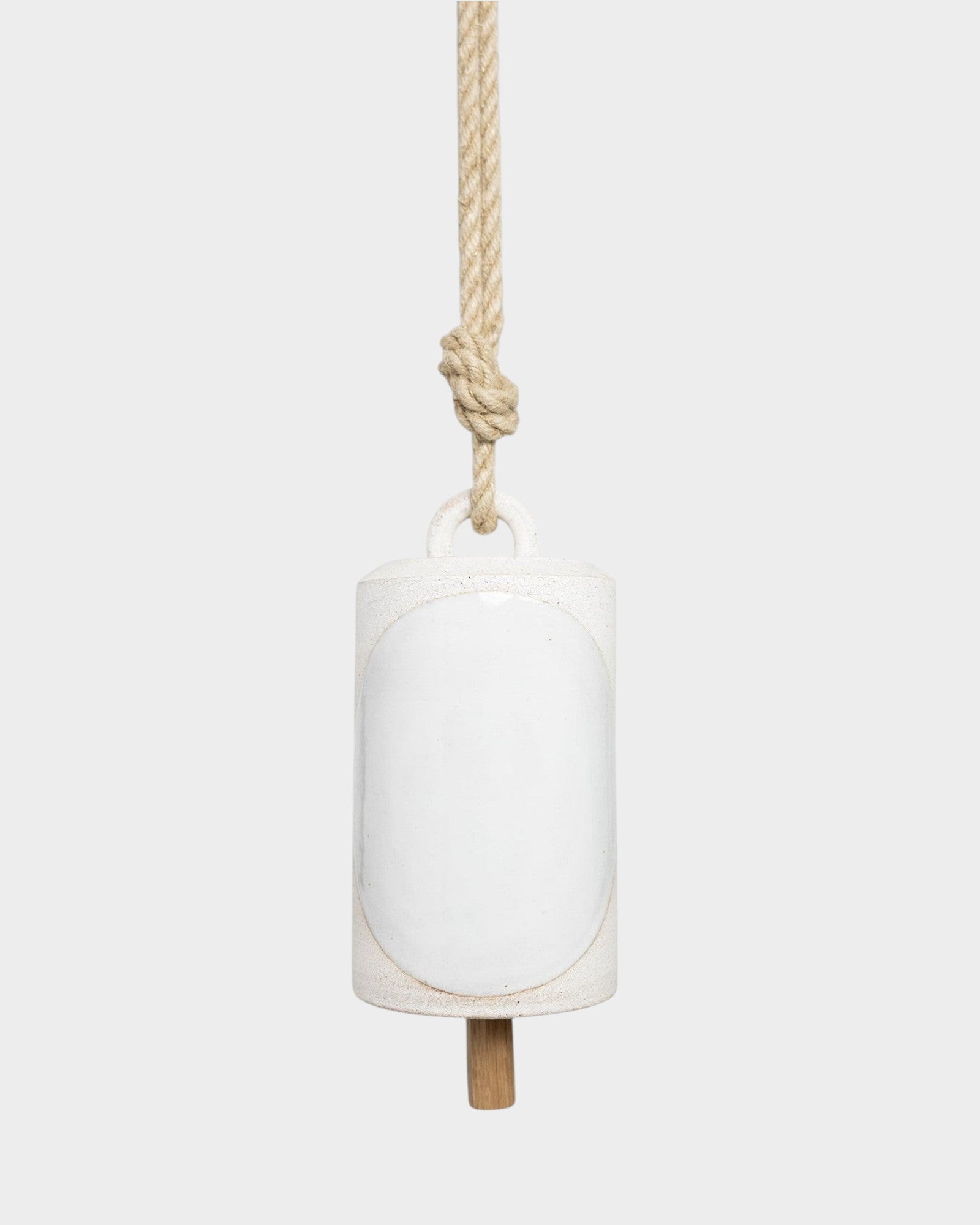 JONES + CO Thrown Bell in Domino Indigo, a white ceramic hanging bell with a rustic rope and wooden clapper.