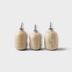 JONES + CO handmade ceramic olive oil cruets with metal spouts in a natural beige glaze finish.