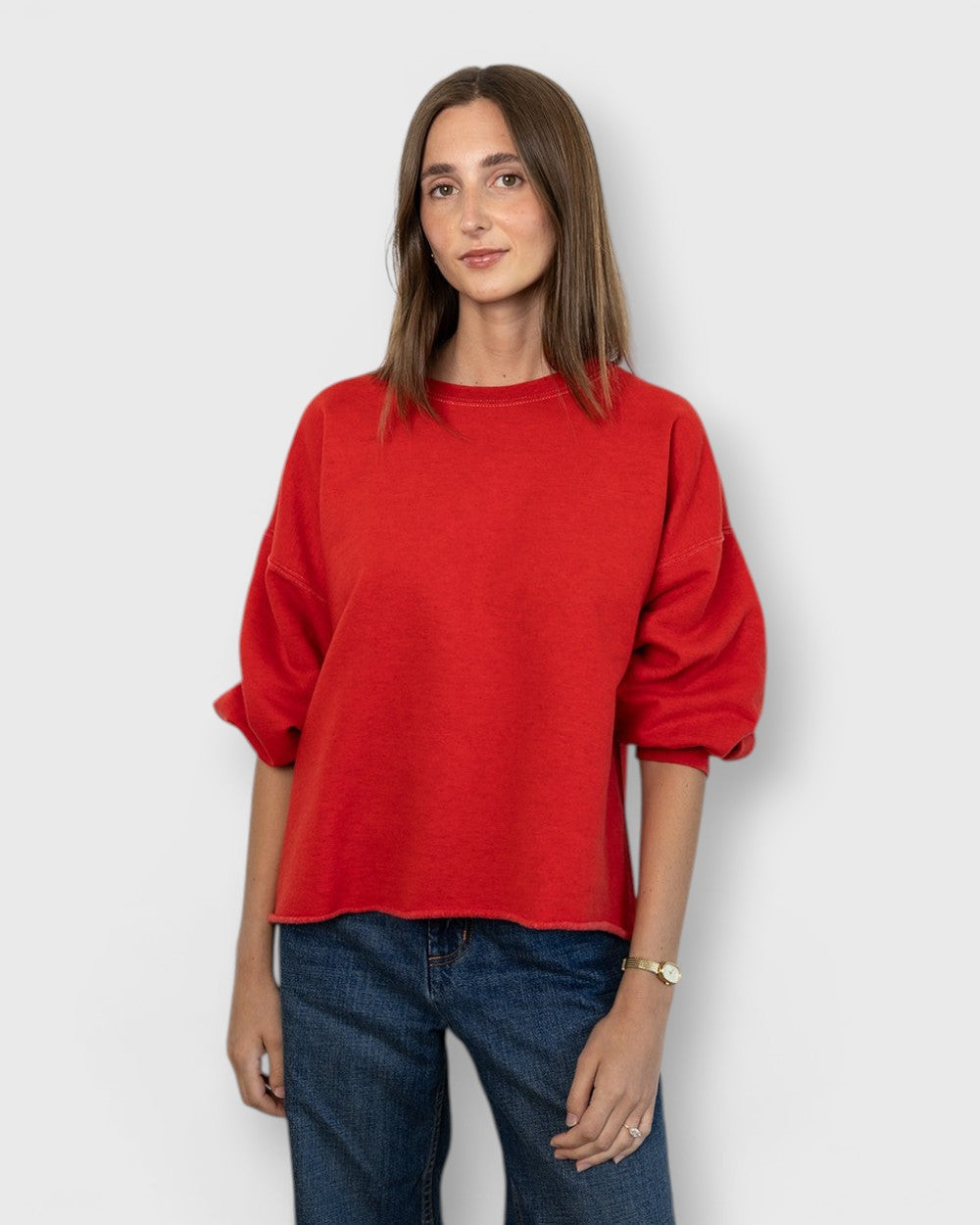 JONES + CO model wearing a cherry red Rachel Comey Fond crewneck sweatshirt with drop shoulders and raw edge hem.