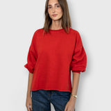 JONES + CO model wearing a cherry red Rachel Comey Fond crewneck sweatshirt with drop shoulders and raw edge hem.