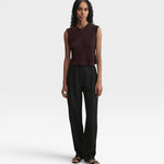 Model wearing a JONES + CO chocolate brown sleeveless cotton boucle crewneck top with picot trim and black trousers.