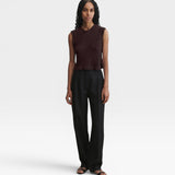 Model wearing a JONES + CO chocolate brown sleeveless cotton boucle crewneck top with picot trim and black trousers.