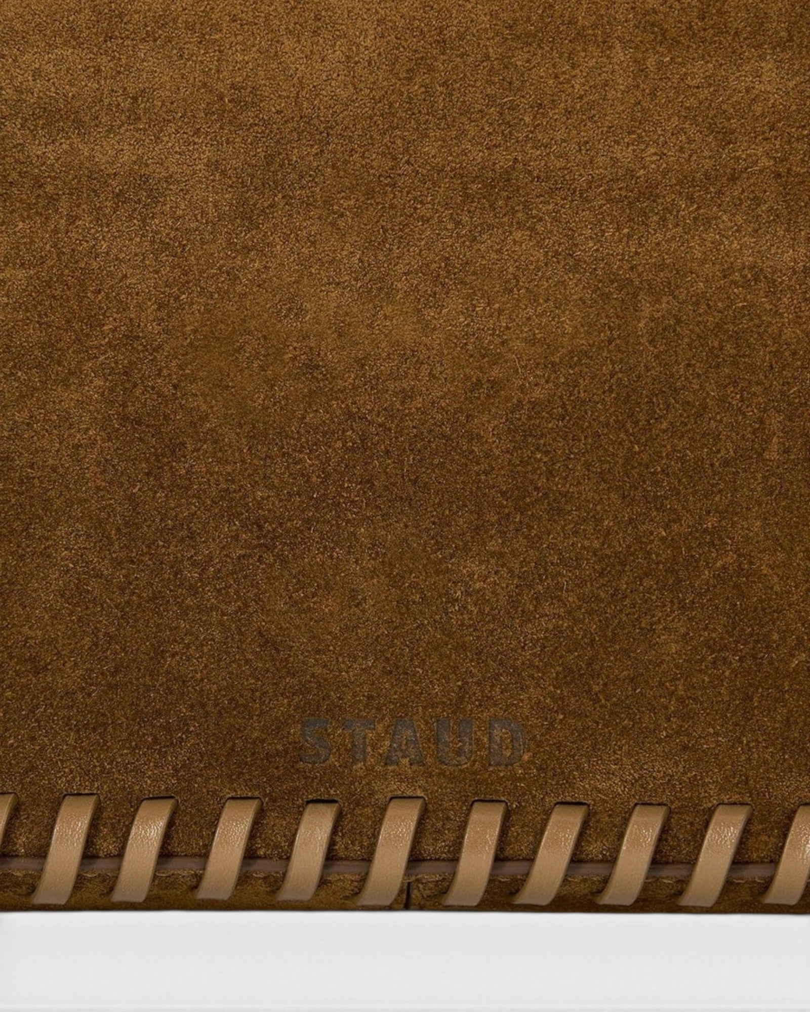JONES + CO Harlow Bag in cigar brown suede featuring decorative leather whipstitch edging and embossed logo detail.