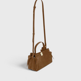 JONES + CO Gyoza Mini handbag in cognac suede with gold-tone hardware and adjustable shoulder strap, side view.