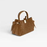 JONES + CO Gyoza Mini handbag in cognac suede with a top handle, knotted side details, and gold-tone hardware.
