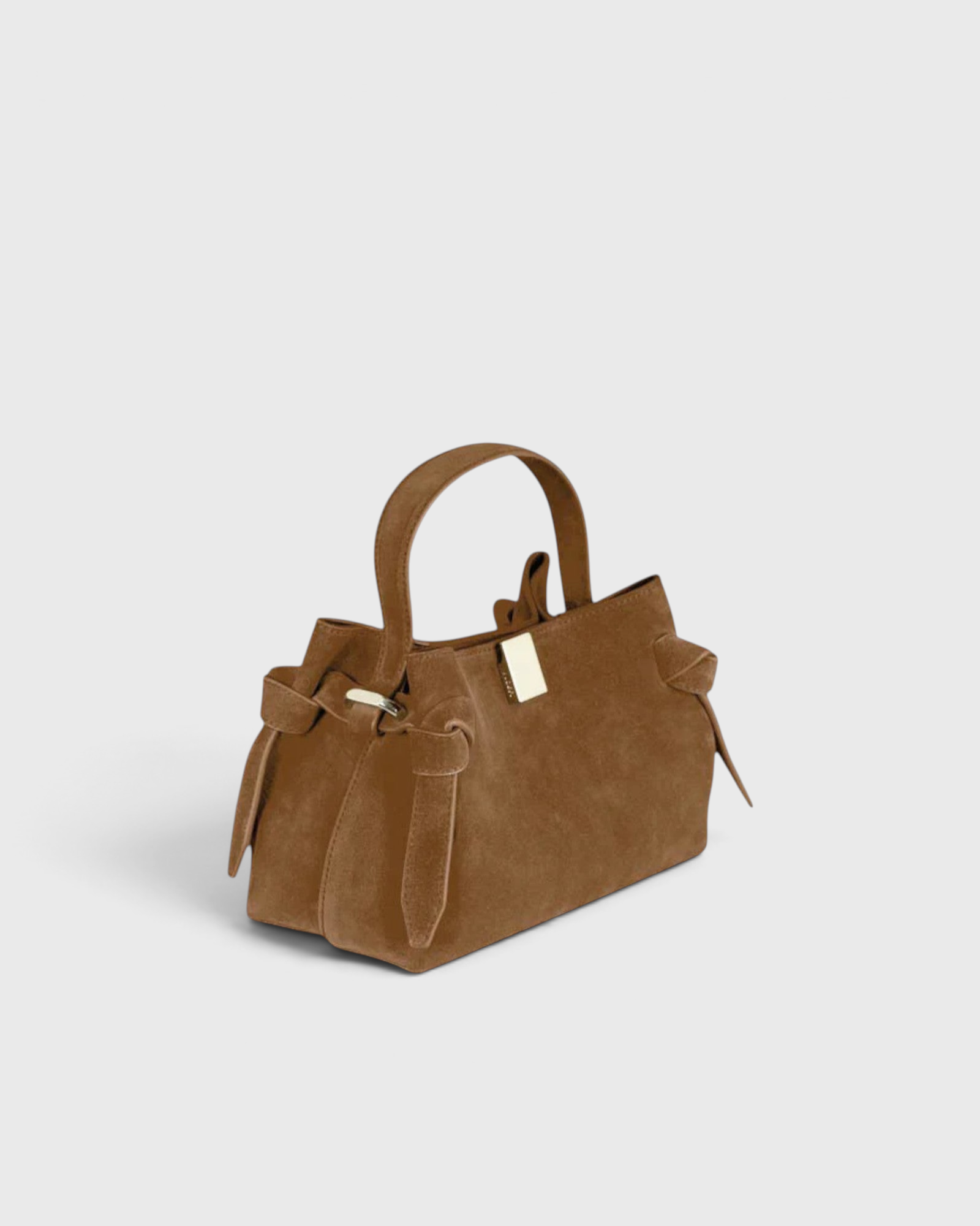 JONES + CO Gyoza Mini handbag in cognac suede with a top handle, knotted side details, and gold-tone hardware.