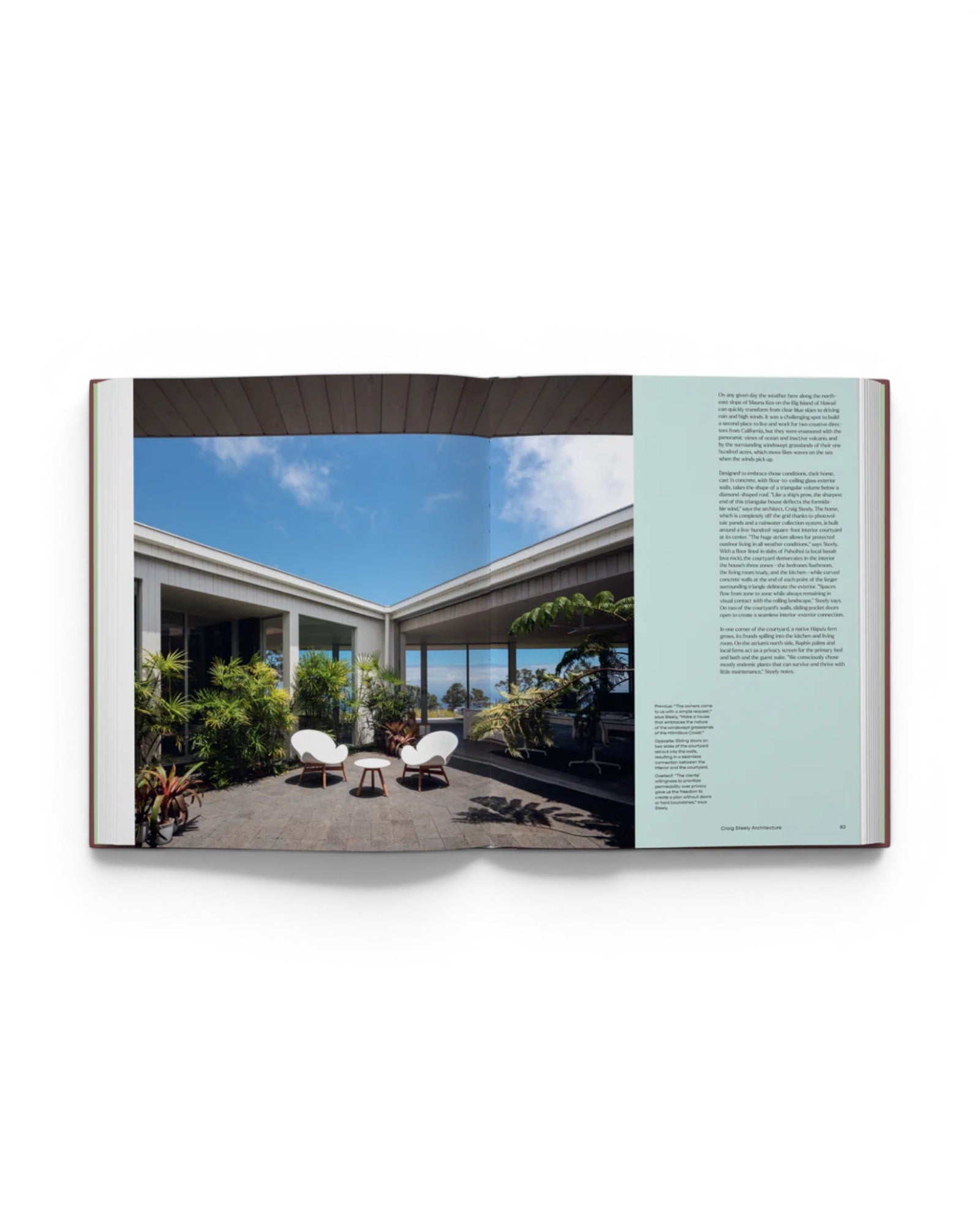 JONES + CO Courtyard Homes book open to a page showing a modern outdoor courtyard with white chairs and lush plants.