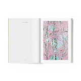JONES + CO art book open to a page featuring Damien Hirst's vibrant pink and blue Cherry Blossoms painting
