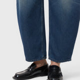 JONES + CO Jazzie barrel jeans in dark blue denim with a cropped leg, paired with black leather loafers.