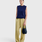 JONES + CO Bucket Tool bag in dark indigo lustre leather with vertical stitching, held by a model in a studio setting.