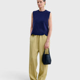 JONES + CO Bucket Tool bag in dark indigo lustre leather with vertical stitching, held by a model in a studio setting.