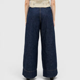 JONES + CO dark indigo wide-leg denim trousers with a high-waisted pleated fit, viewed from the back.
