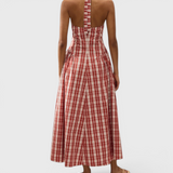 JONES + CO Del Rose midi dress in terra rosso check cotton with a halterneck and open back, worn by a model.
