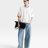 JONES + CO model wearing a dirty white Rachel Comey Fond crewneck sweatshirt with drop shoulders and raw edge hem.
