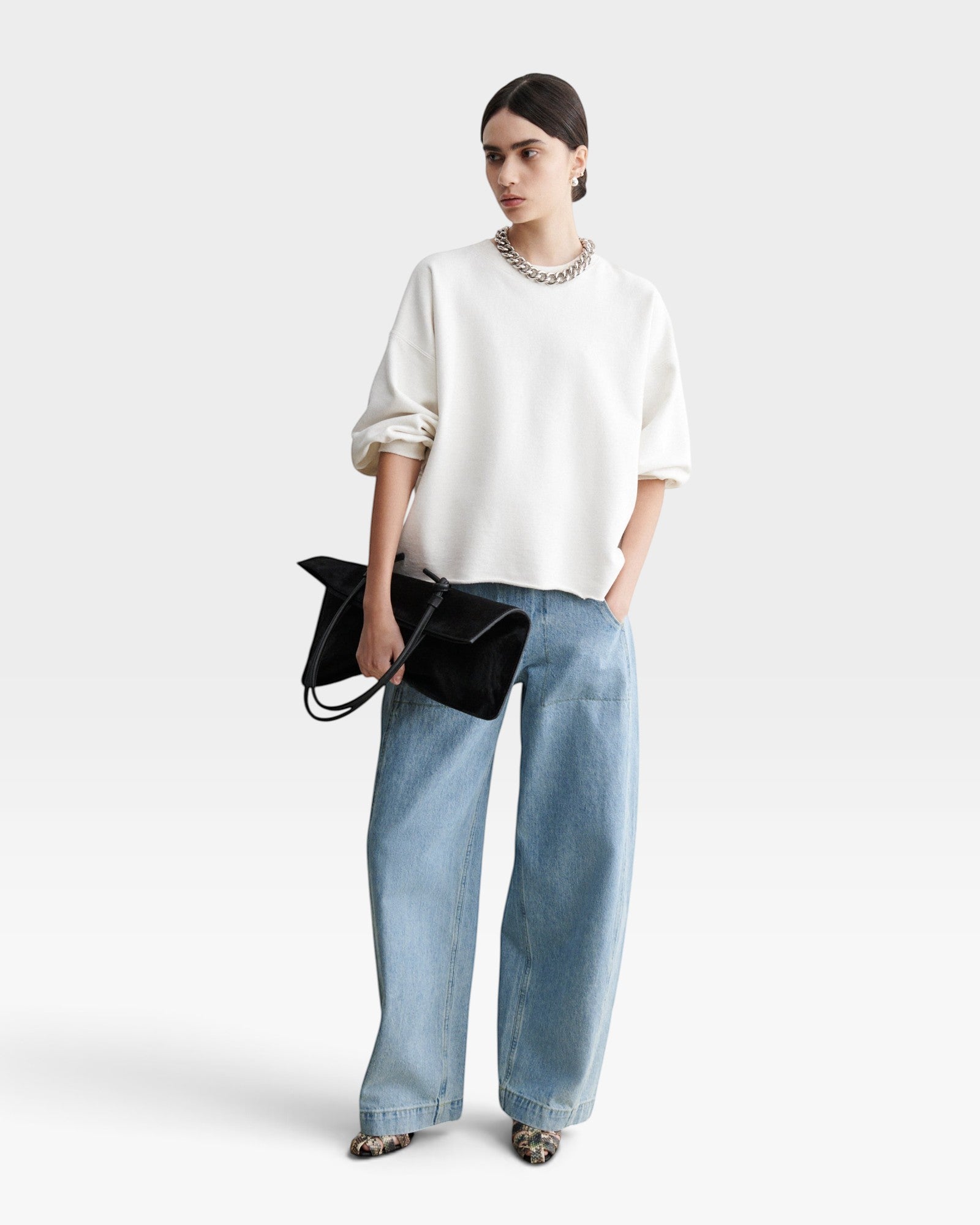 JONES + CO model wearing a dirty white Rachel Comey Fond crewneck sweatshirt with drop shoulders and raw edge hem.