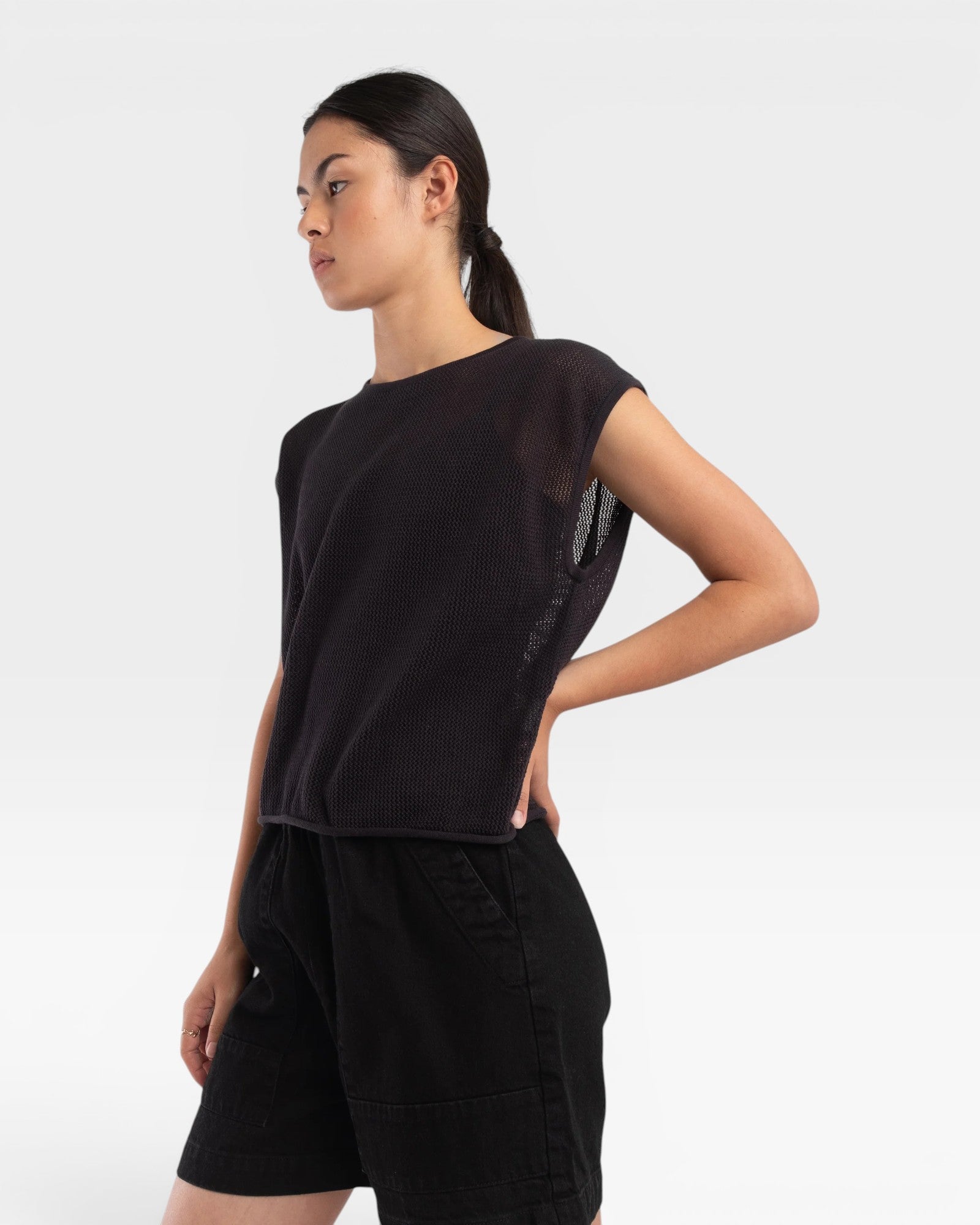 JONES + CO faded black boxy tank top in an airy fine mesh stitch with refined trim details worn by a model.